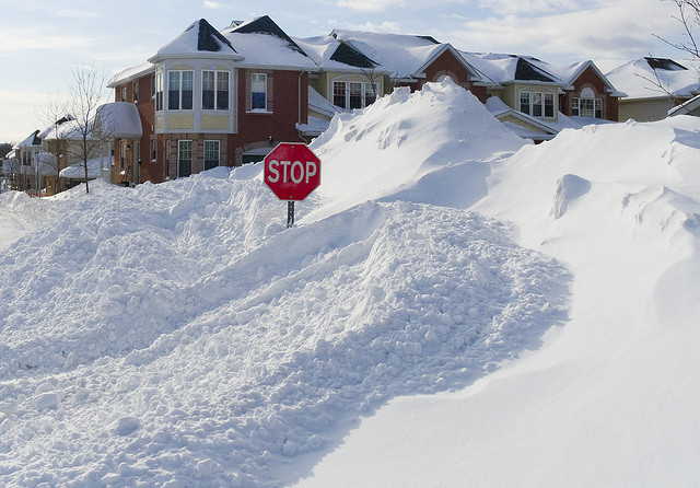 big pile of snow with stop sign poking out