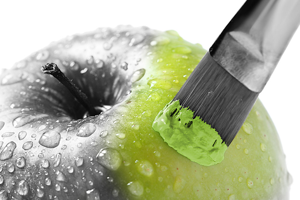 black and white apple being painted green