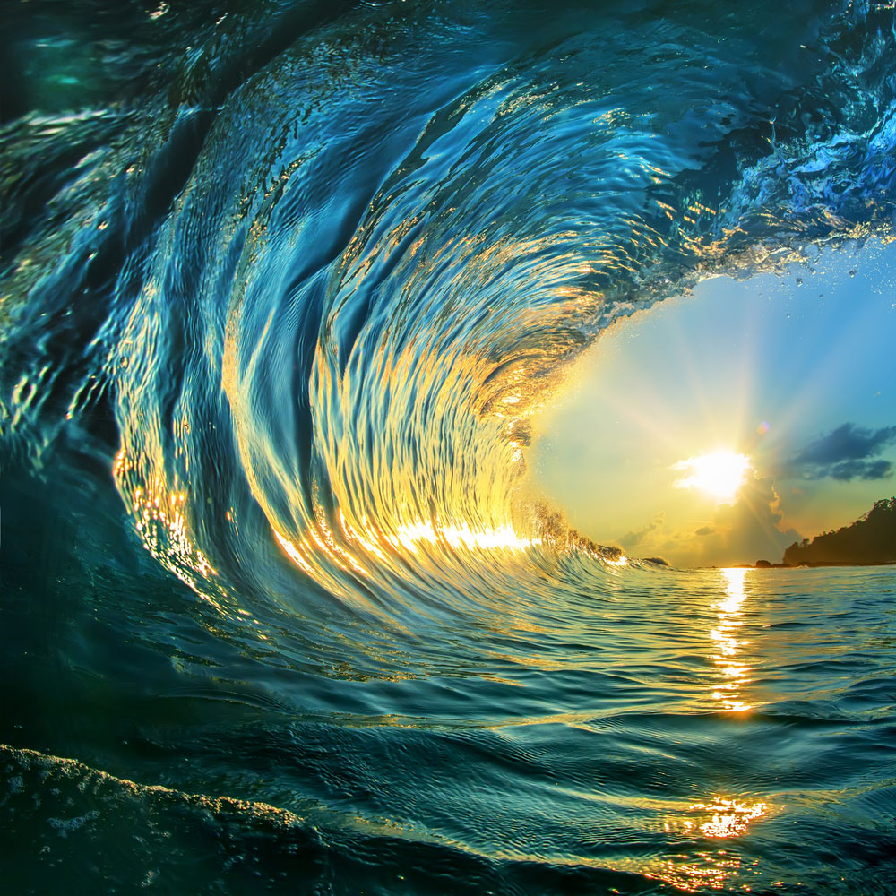 Large wave with bright sun in the background