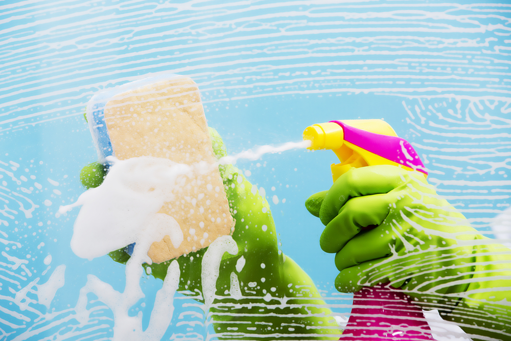 Soapy sponge and bottle of spray cleaner